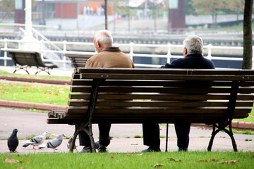 Hombres ancianos sentado en un banco del parque