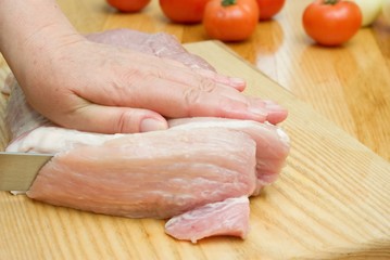 preparing meat with woman hand and knife.