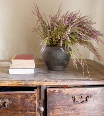 Wooden commode with books stack and pot