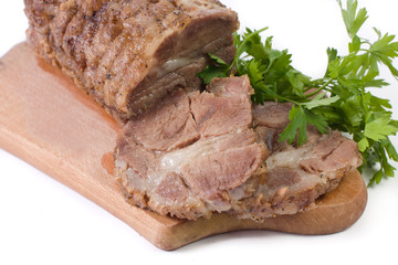 Appetizing piece of roasted meat on a wood piece with parsley