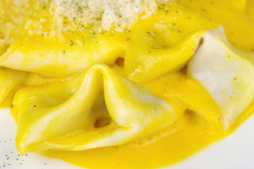 Ravioli with cheese sauce and grated cheese on top