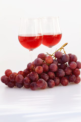 glass of wine and a bunch of grapes isolated on white