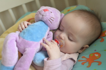 baby sleeping with a cuddly toy