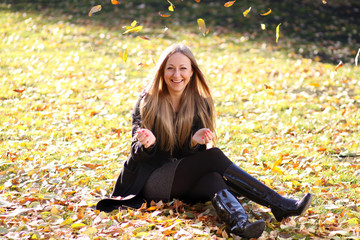 happy girl throwing autumn leaves