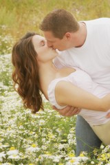Obraz premium Couple Kiss In A Field Of Daisies