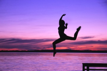 Fototapeta na wymiar Woman Leaps Into The Water