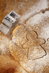 gingerbread girl cookie cutter from above with dough on wood, ve