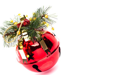 Shiny red jingle bell with a holly sprig isolated on white