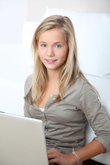 Blond girl sitting in sofa surfing on internet