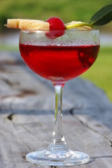 red cocktail drink on wooden chair outdoor 