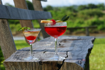 red cocktail drink on wooden chair outdoor 