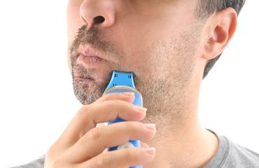 Adult man shaving his beard off with an electric shaver.
