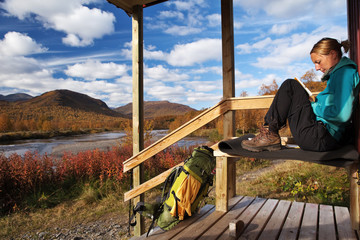 Wanderin macht vor einer Hütte eine Pause