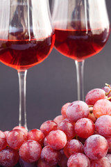 glass of wine and a bunch of grapes on a black background