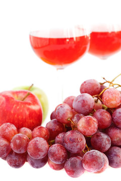 glass of wine and a bunch of grapes isolated on white