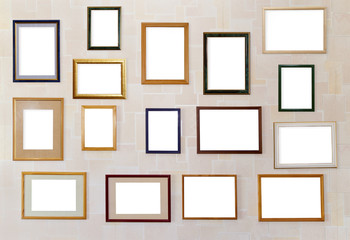 Many various photo frames  hang on a wall.