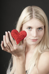 Junge attraktive blonde Frau mit Herz