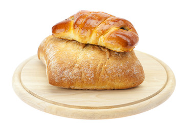 bread and loaf with poppy seeds on a cutting board isolated on w