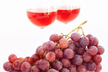 glass of wine and a bunch of grapes isolated on white