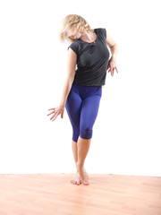 Young woman dancing modern jazz on wood floor © Selecstock