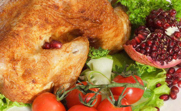 Roast chicken with tomatoes and a pomegranate