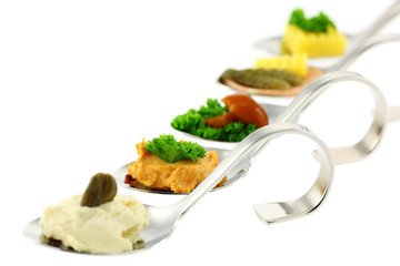 Different canapes on funny spoons