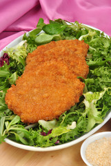 panierte Hühnerfilets auf grünem Salat