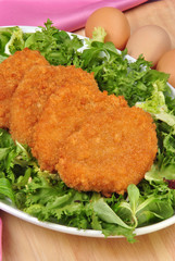 panierte Hühnerfilets auf grünem Salat
