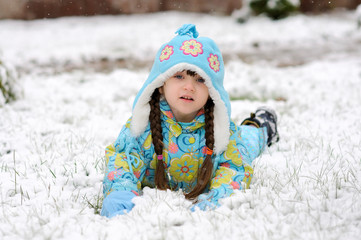 Winter toddler girl in warm hat in forest