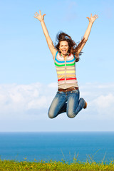 Beautiful young woman jumping up in the air smiling