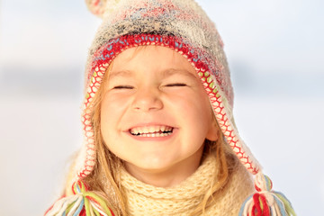 Mädchen mit Pudelmütze lacht