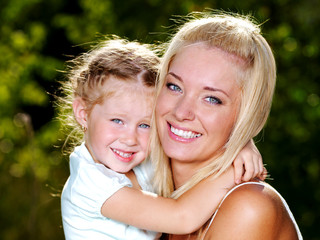 smiling and beautiful mother and little daughter