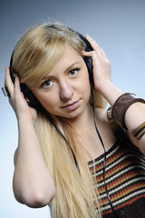 young woman choosing music on headphones