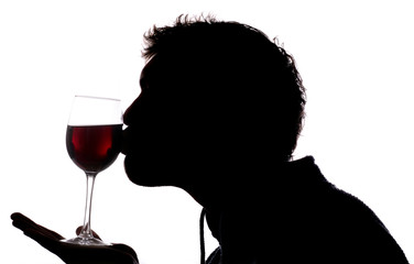 Man kissing glass of red wine silhouette
