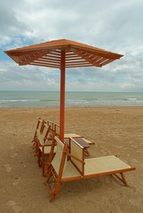 Beach umbrella and sunbeds in a cloudy day