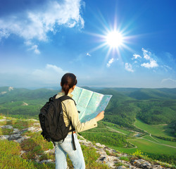 Girl tourist in mountain read the map.