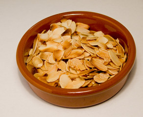 Toasted flahedalmonds in a small round terracota dish