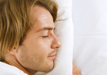 Fototapeta na wymiar Young Man Sleeping in his Bed