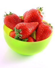 Few strawberries in green cup isolated on white