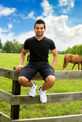 Man sitting on fence countryside