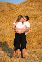 Naklejka na ściany i meble The guy embraces and kisses the pregnant girl
