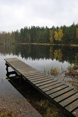 Naklejka premium Traditional wooden Swedish bridge in rainy day