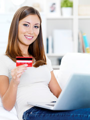 woman holding credit card with laptop