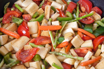 Close-up of vegetables being stir-fried.