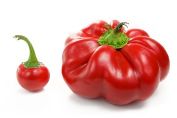 big and small red peppers over white