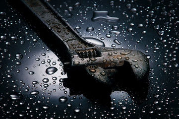 Fototapeta na wymiar Adjustable spanner , water drops background , wrench