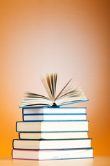 Stack of text books against gradient background