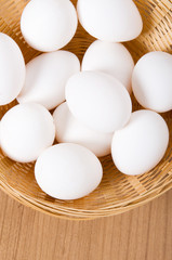 Many white eggs on the wooden table