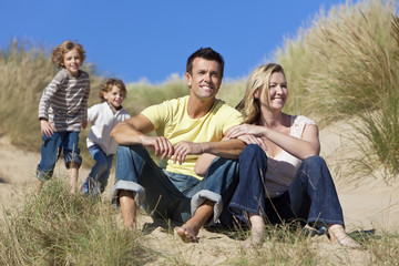 Family Sitting on Beach Having Fun