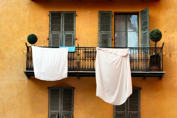 Washing sheets hanging on old balcony